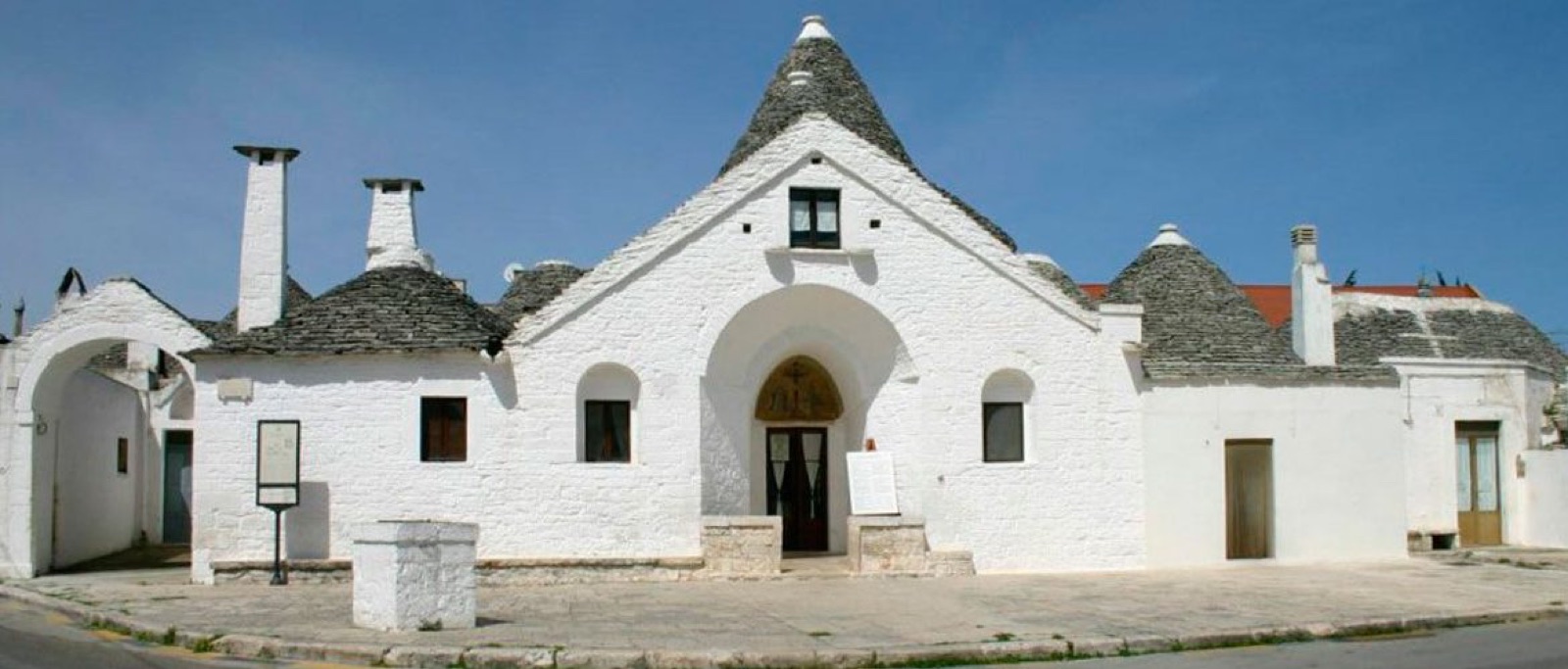 Il Trullo Sovrano di Alberobello: facciata bianca e coni in pietra grigia.