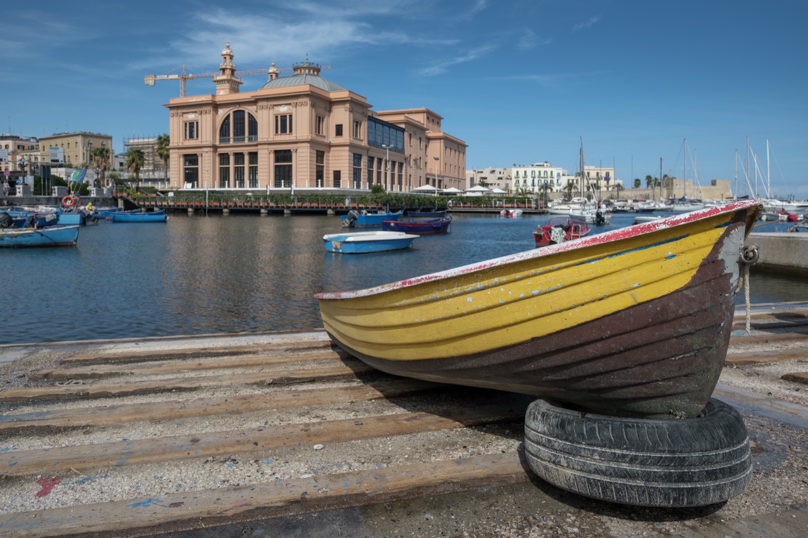 Una barca da pesca sulla banchina del porto vecchio di Bari, con il Teatro Margherita sullo sfondo.