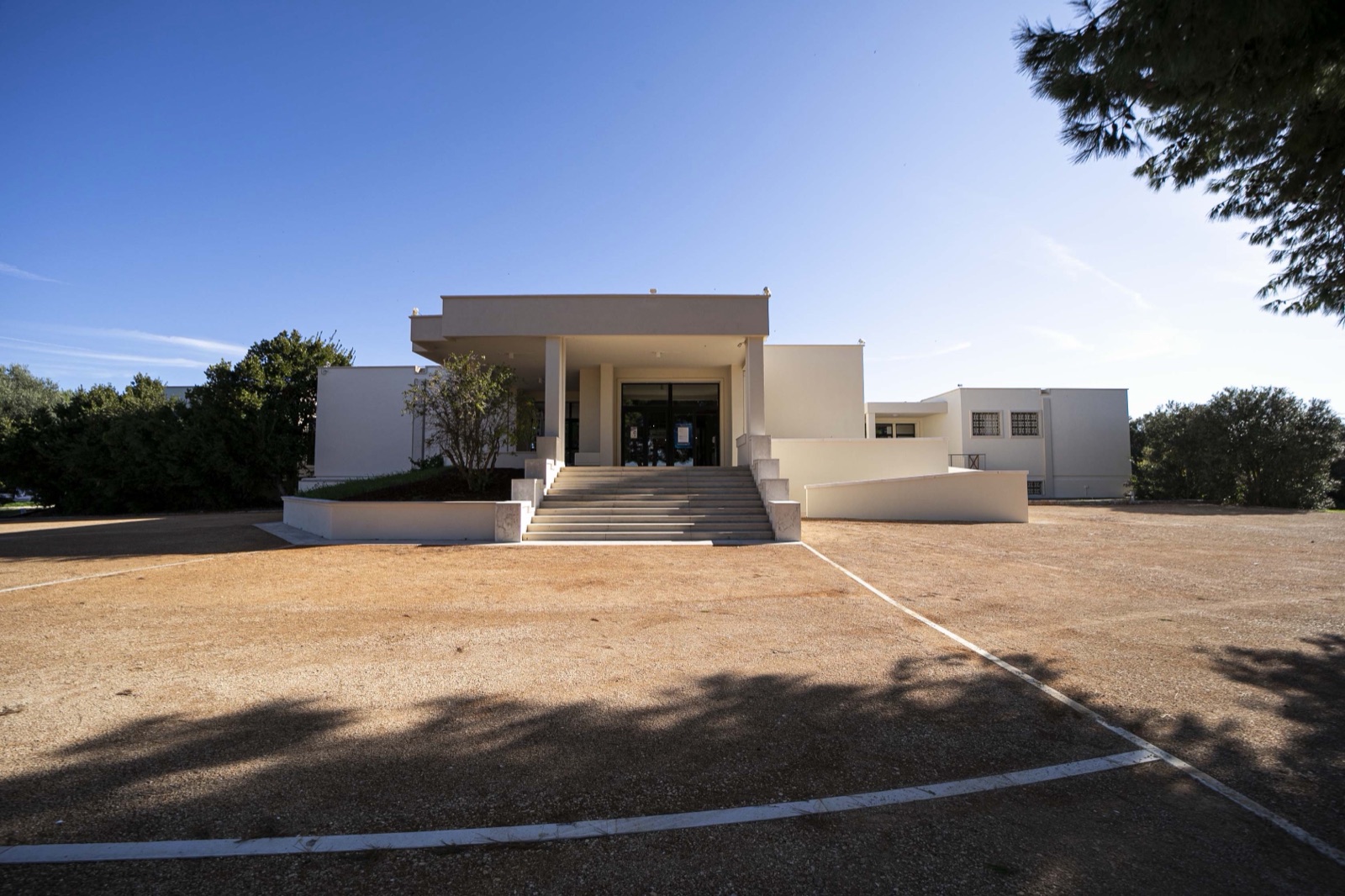 L’ingresso del Museo archeologico nazionale di Egnazia, edificio chiaro tra la vegetazione mediterranea.