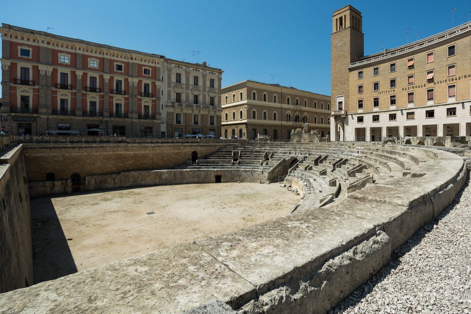 L’anfiteatro romano in piazza Sant’Oronzo a Lecce, circondato da edifici in pietra chiara.