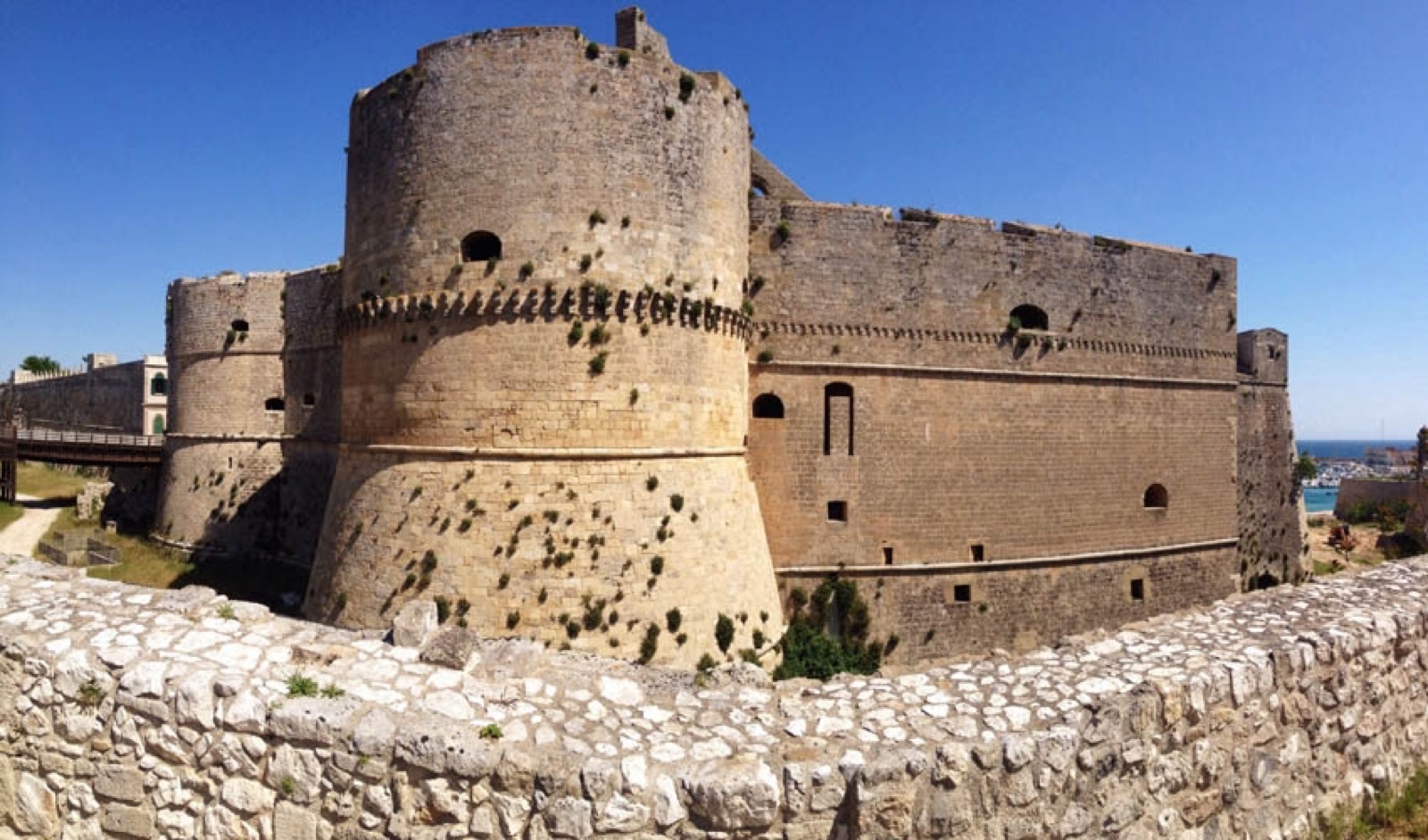 I bastioni rotondi del Castello aragonese di Otranto sotto il cielo estivo.